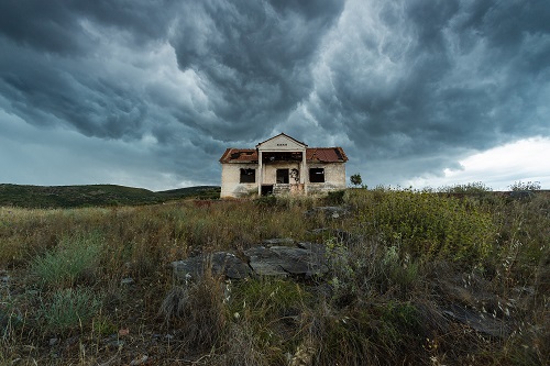 haunted house on a hill with ominous skies